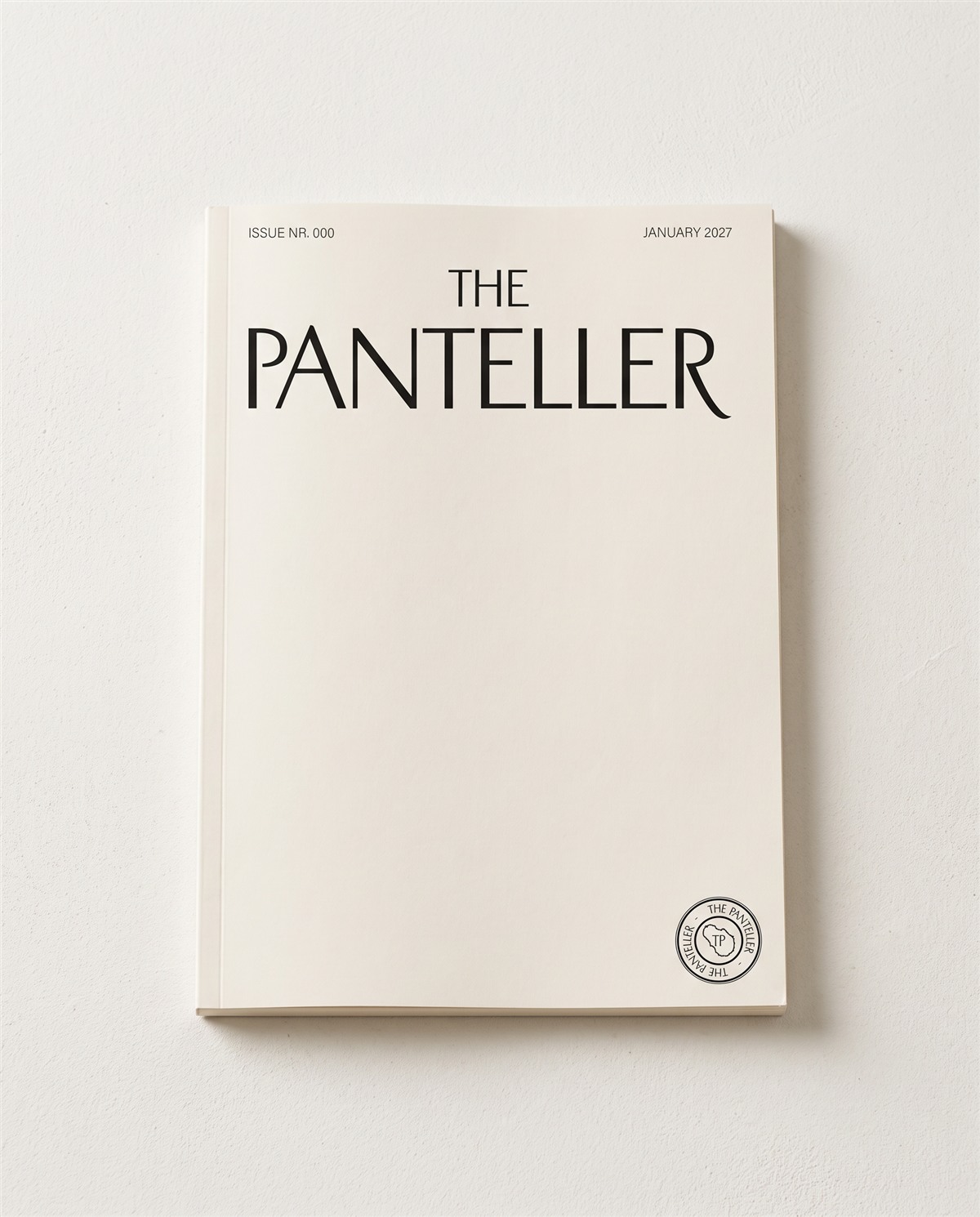 La copertina bianca numero 000 di The Panteller su una rivista, appoggiata su una superficie bianca in luce naturale